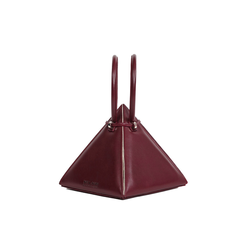 Buy now the Iconic LIA Mini bag inspired by the geometric shapes of our designer's birth city Barcelona, and its world known artist, Antonio Gaudí, architect of the world wonder La Sagrada Familia. The Iconic Lia Burgundy Mini bag has a unique and functional pyramidal design able to fit all your essentials.