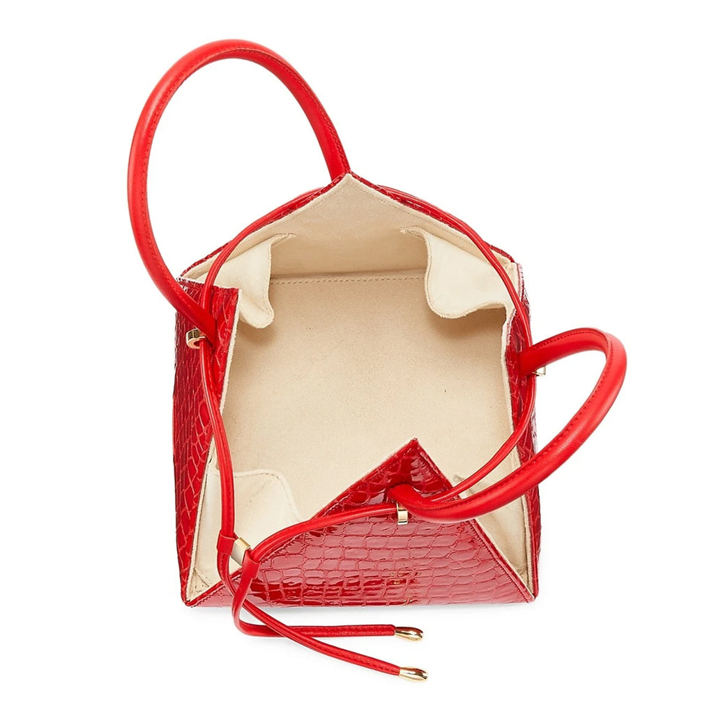 Buy now the Exotic Lia Handbag inspired by the geometric shapes of our designer's birth city Barcelona, and its world known artist, Antonio Gaudí, architect of the world wonder La Sagrada Familia. The Exotic Lia Croc-Embossed Passion Red Handbag has a unique and functional pyramidal design able to fit all your essentials. 