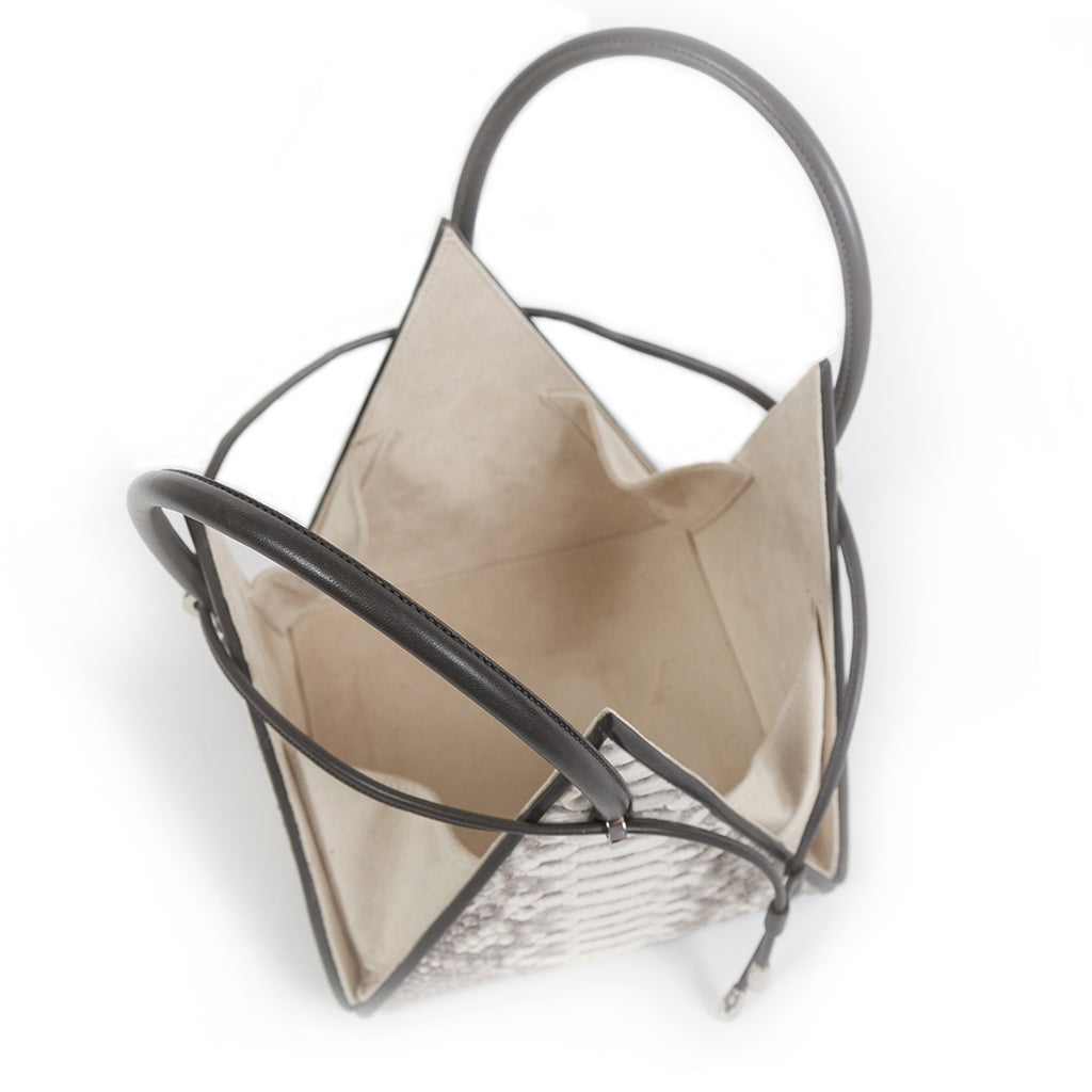 Buy now the Exotic Lia Handbag inspired by the geometric shapes of our designer's birth city Barcelona, and its world known artist, Antonio Gaudí, architect of the world wonder La Sagrada Familia. The Iconic Lia Python Natural Handbag has a unique and functional pyramidal design able to fit all your essentials. 