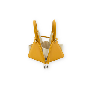 Buy now the Iconic Lia Handbag inspired by the geometric shapes of our designer's birth city Barcelona, and its world known artist, Antonio Gaudí, architect of the world wonder La Sagrada Familia. The Iconic Lia Amber Mini bag has a unique and functional pyramidal design able to fit all your essentials. 