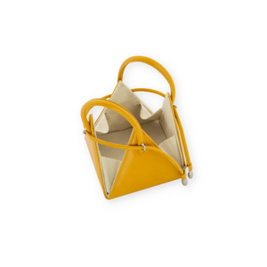 Buy now the Iconic Lia Handbag inspired by the geometric shapes of our designer's birth city Barcelona, and its world known artist, Antonio Gaudí, architect of the world wonder La Sagrada Familia. The Iconic Lia Amber Mini bag has a unique and functional pyramidal design able to fit all your essentials. 