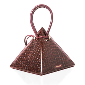 Buy now the Exotica Lia Handbag inspired by the geometric shapes of our designer's birth city Barcelona, and its world known artist, Antonio Gaudí, architect of the world wonder La Sagrada Familia. The Exotic Lia Croc-Embossed Burgundy Handbag has a unique and functional pyramidal design able to fit all your essentials. 