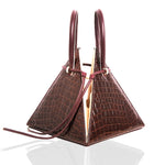 Buy now the Exotica Lia Handbag inspired by the geometric shapes of our designer's birth city Barcelona, and its world known artist, Antonio Gaudí, architect of the world wonder La Sagrada Familia. The Exotic Lia Croc-Embossed Burgundy Handbag has a unique and functional pyramidal design able to fit all your essentials. 