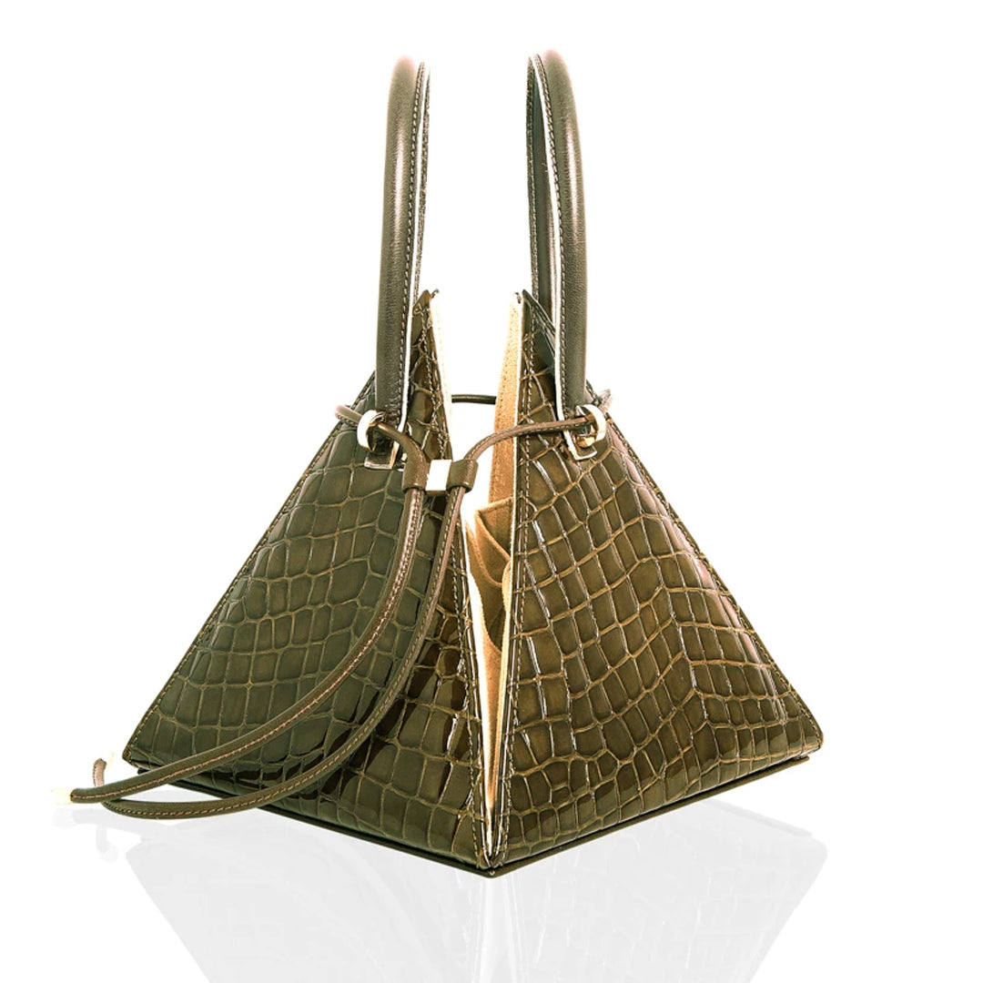 Buy now the Exotic Lia Handbag inspired by the geometric shapes of our designer's birth city Barcelona, and its world known artist, Antonio Gaudí, architect of the world wonder La Sagrada Familia. The Exotic Lia Croc-Embossed Pino Green Handbag has a unique and functional pyramidal design able to fit all your essentials. 