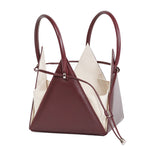 Buy now the Iconic Lia Handbag inspired by the geometric shapes of our designer's birth city Barcelona, and its world known artist, Antonio Gaudí, architect of the world wonder La Sagrada Familia. The Iconic Lia Burgundy Handbag has a unique and functional pyramidal design able to fit all your essentials.