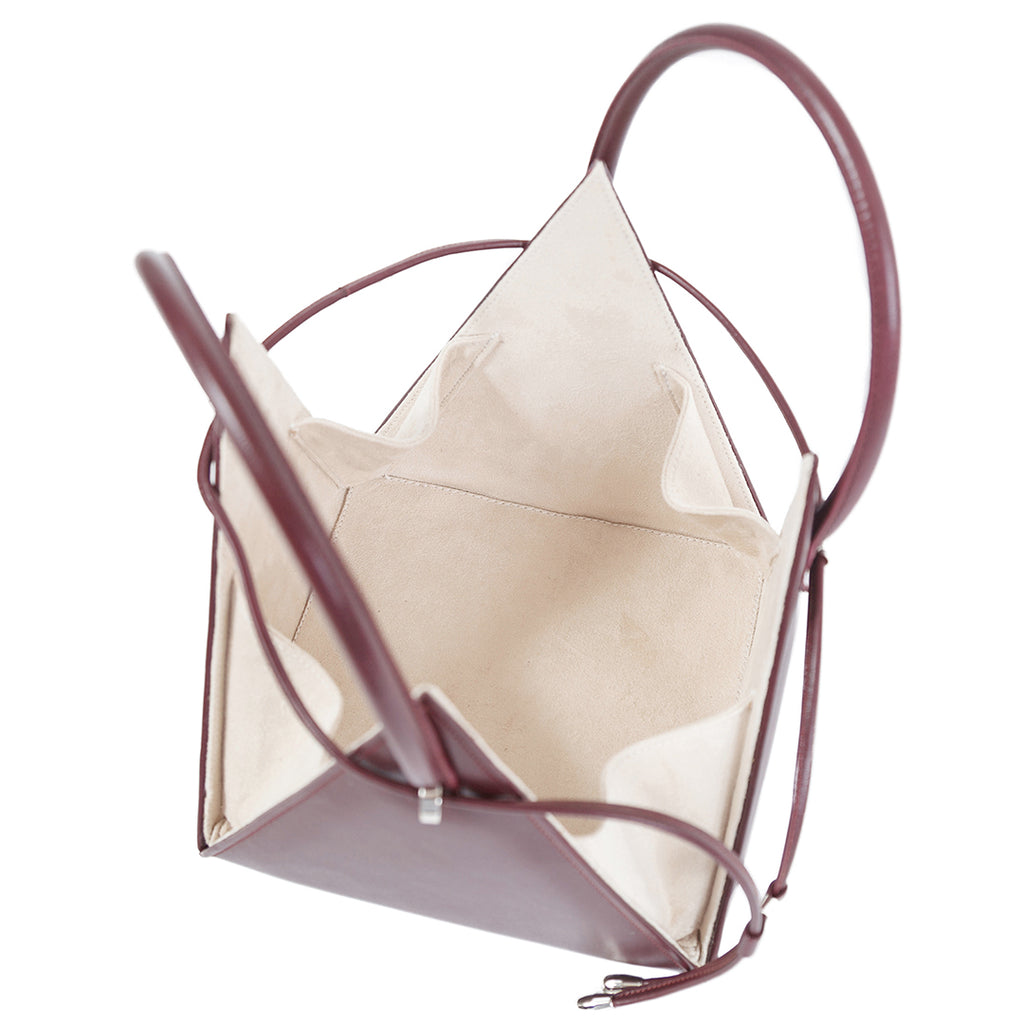 Buy now the Iconic Lia Handbag inspired by the geometric shapes of our designer's birth city Barcelona, and its world known artist, Antonio Gaudí, architect of the world wonder La Sagrada Familia. The Iconic Lia Burgundy Handbag has a unique and functional pyramidal design able to fit all your essentials.