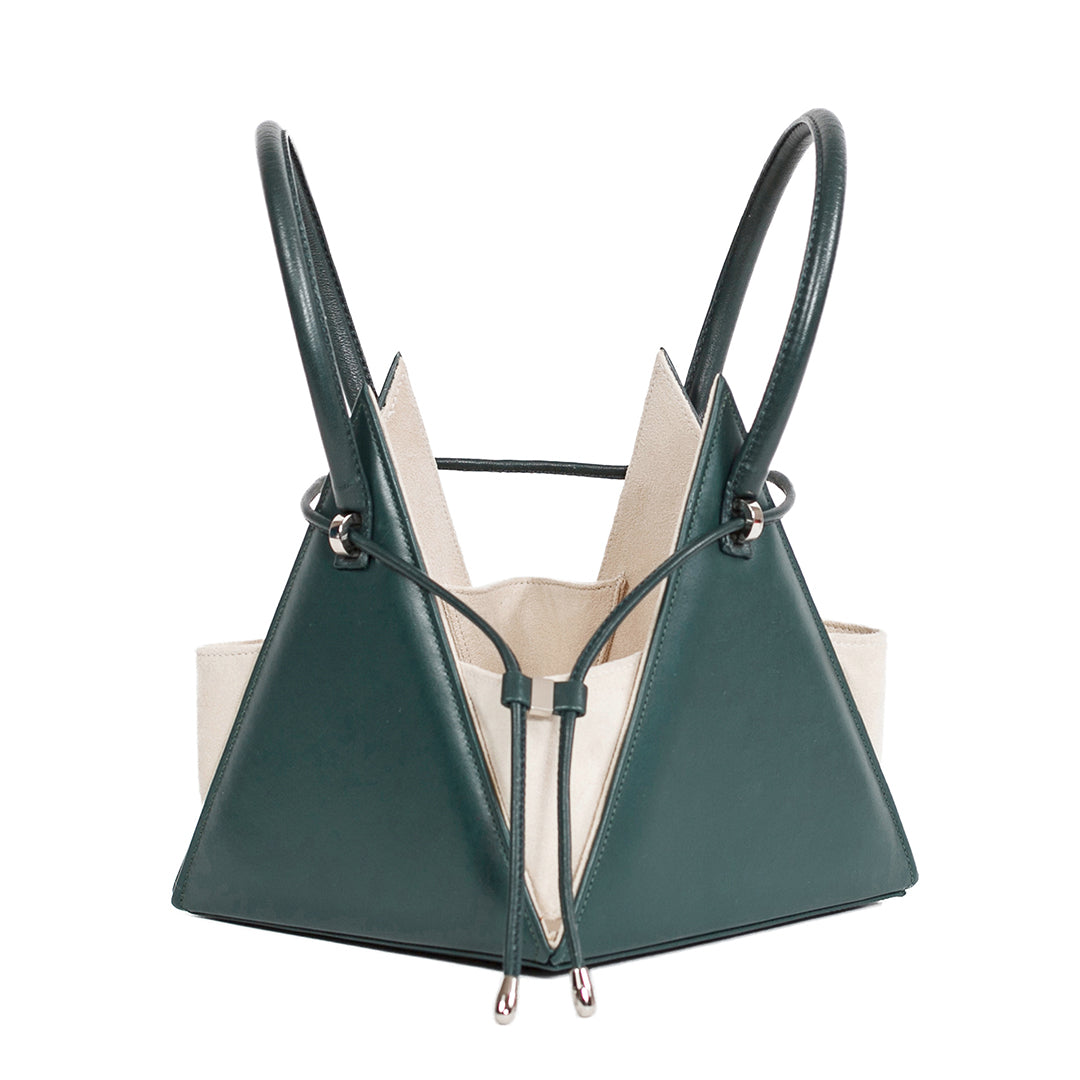 Buy now the Iconic Lia Handbag inspired by the geometric shapes of our designer's birth city Barcelona, and its world known artist, Antonio Gaudí, architect of the world wonder La Sagrada Familia. The Iconic Lia Cipresso Green Handbag has a unique and functional pyramidal design able to fit all your essentials. 