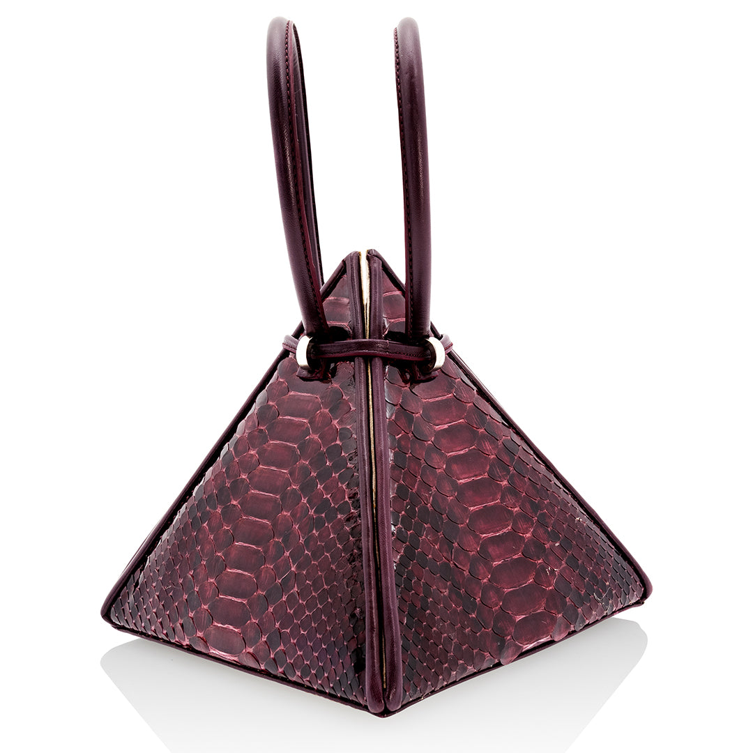 Buy now the Exotic Lia Handbag inspired by the geometric shapes of our designer's birth city Barcelona, and its world known artist, Antonio Gaudí, architect of the world wonder La Sagrada Familia. The Exotic Lia Python Burgundy Handbag has a unique and functional pyramidal design able to fit all your essentials. 