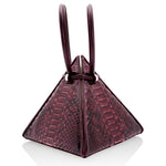Buy now the Exotic Lia Handbag inspired by the geometric shapes of our designer's birth city Barcelona, and its world known artist, Antonio Gaudí, architect of the world wonder La Sagrada Familia. The Exotic Lia Python Burgundy Handbag has a unique and functional pyramidal design able to fit all your essentials. 