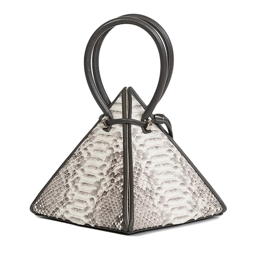 Buy now the Exotic Lia Handbag inspired by the geometric shapes of our designer's birth city Barcelona, and its world known artist, Antonio Gaudí, architect of the world wonder La Sagrada Familia. The Iconic Lia Python Natural Handbag has a unique and functional pyramidal design able to fit all your essentials. 