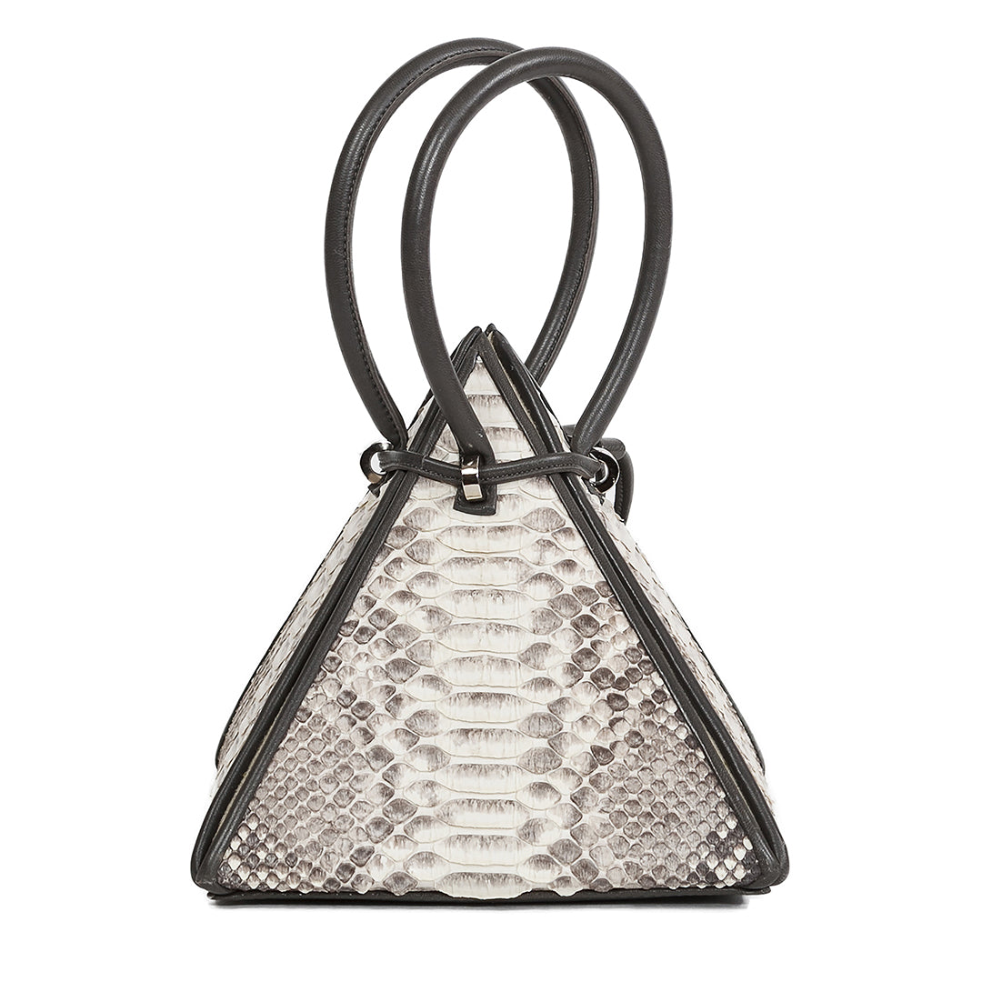 Buy now the Exotic Lia Handbag inspired by the geometric shapes of our designer's birth city Barcelona, and its world known artist, Antonio Gaudí, architect of the world wonder La Sagrada Familia. The Iconic Lia Python Natural Handbag has a unique and functional pyramidal design able to fit all your essentials. 