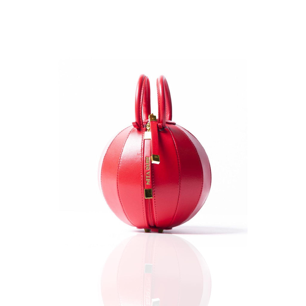 Buy now the iconic Pilo Minibag inspired by the geometric shapes of our designer's birth city Barcelona, and its world known artist, Antonio Gaudí, architect of the world wonder La Sagrada Familia. The iconic Pilo Red Minibag has a unique and functional sphere design able to fit all your essentials. 