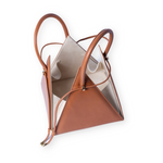 Buy now the Iconic Lia Handbag inspired by the geometric shapes of our designer's birth city Barcelona, and its world known artist, Antonio Gaudí, architect of the world wonder La Sagrada Familia. The Iconic Lia Cuero Tan Handbag has a unique and functional pyramidal design able to fit all your essentials. 