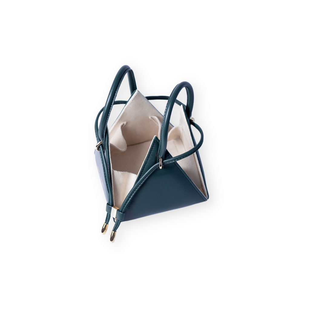 Buy now the Iconic LIA Mini bag inspired by the geometric shapes of our designer's birth city Barcelona, and its world known artist, Antonio Gaudí, architect of the world wonder La Sagrada Familia. The Iconic Lia Forest Green Mini bag has a unique and functional pyramidal design able to fit all your essentials. 