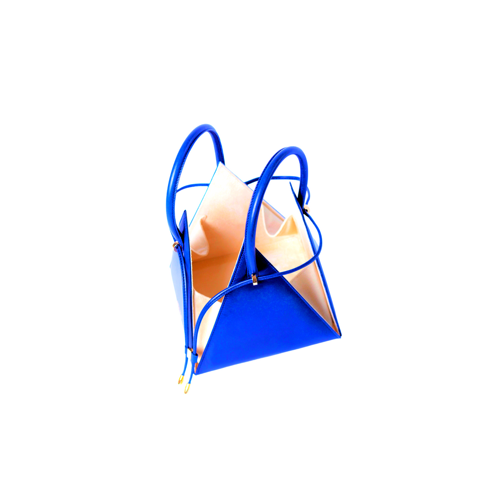 Buy now the Iconic LIA Mini bag inspired by the geometric shapes of our designer's birth city Barcelona, and its world known artist, Antonio Gaudí, architect of the world wonder La Sagrada Familia. The Iconic Lia Electric Blue Mini bag has a unique and functional pyramidal design able to fit all your essentials. 