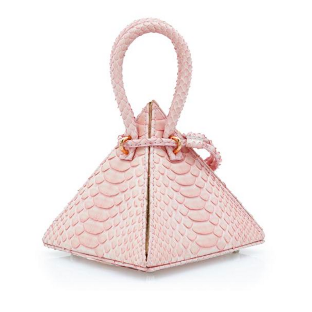 Buy now the Exotic Lia Handbag inspired by the geometric shapes of our designer's birth city Barcelona, and its world known artist, Antonio Gaudí, architect of the world wonder La Sagrada Familia. The Iconic Lia Python Pastel Pink Handbag has a unique and functional pyramidal design able to fit all your essentials. 