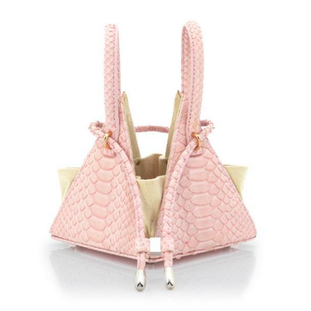 Buy now the Exotic Lia Handbag inspired by the geometric shapes of our designer's birth city Barcelona, and its world known artist, Antonio Gaudí, architect of the world wonder La Sagrada Familia. The Iconic Lia Python Pastel Pink Handbag has a unique and functional pyramidal design able to fit all your essentials. 